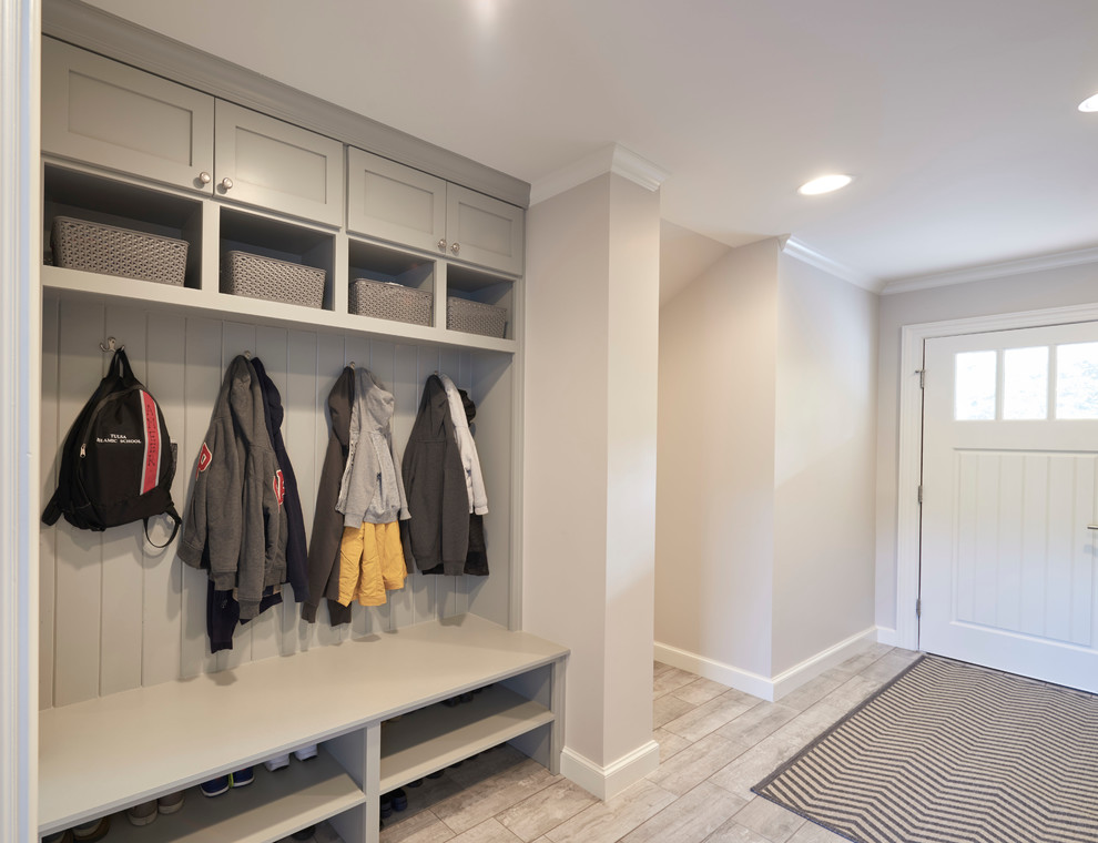 Inspiration for a mid-sized transitional travertine floor mudroom remodel with beige walls and a white front door