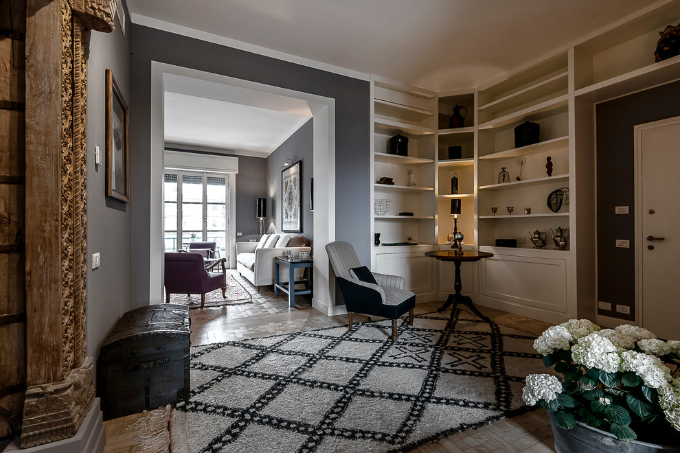 Photo of an eclectic entryway in Milan with grey walls and medium hardwood floors.