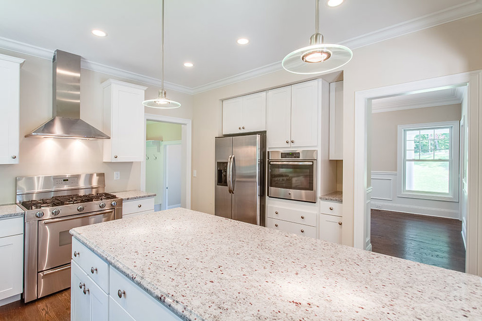 Large transitional l-shaped dark wood floor and brown floor eat-in kitchen photo with shaker cabinets, white cabinets, stainless steel appliances and an island