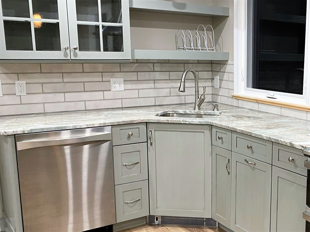 Photo of a medium sized traditional u-shaped kitchen/diner in Boston with a submerged sink, recessed-panel cabinets, grey cabinets, granite worktops, beige splashback, ceramic splashback, stainless steel appliances, vinyl flooring, a breakfast bar, brown floors and multicoloured worktops.