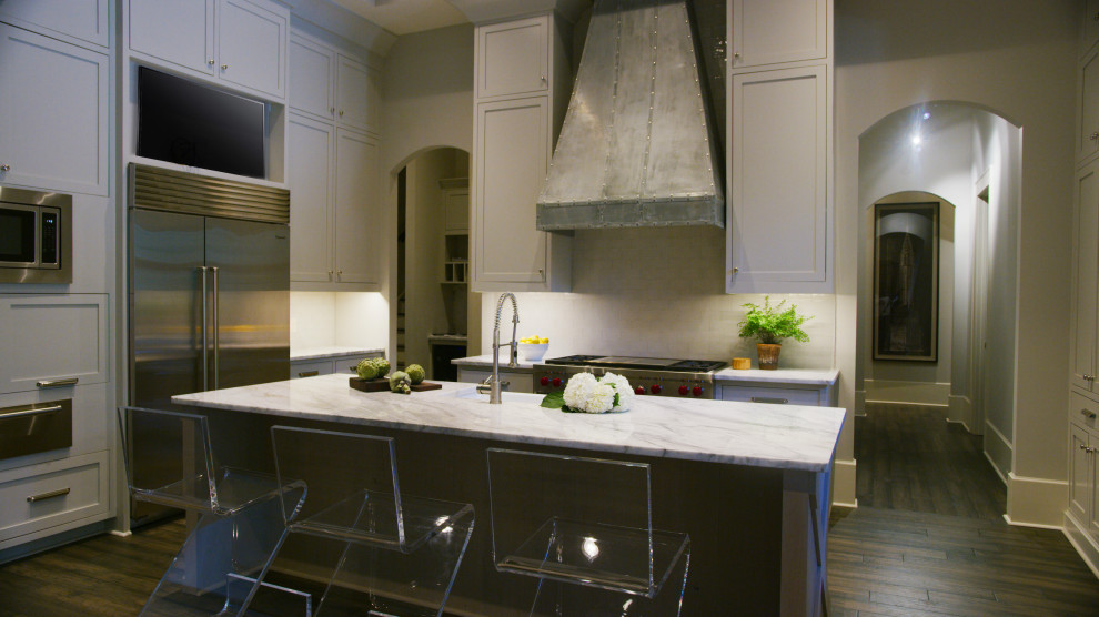 Eat-in kitchen - large transitional u-shaped dark wood floor, gray floor and exposed beam eat-in kitchen idea with a farmhouse sink, flat-panel cabinets, gray cabinets, quartzite countertops, gray backsplash, subway tile backsplash, stainless steel appliances, an island and white countertops