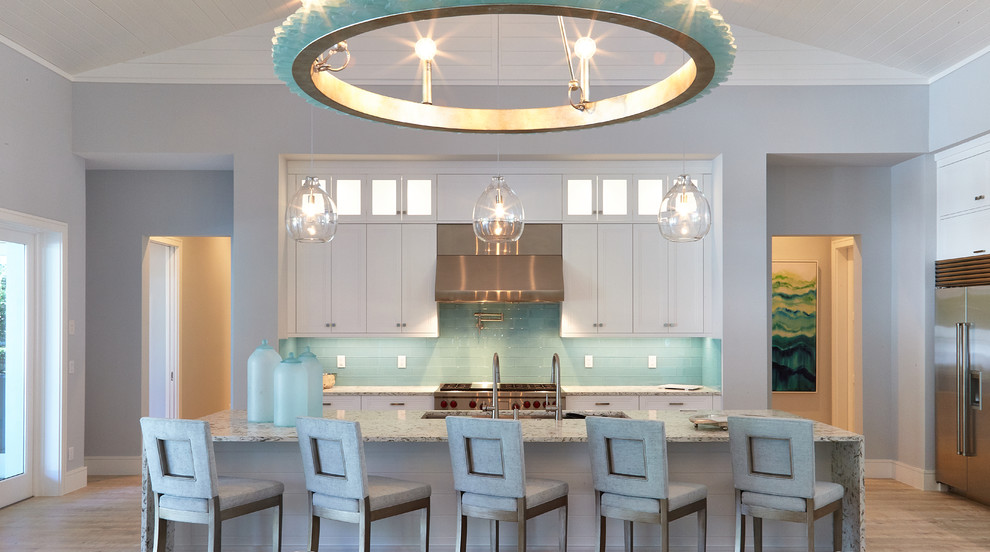 Photo of a transitional u-shaped eat-in kitchen in Miami with with island, an undermount sink, recessed-panel cabinets, white cabinets, blue splashback, subway tile splashback and stainless steel appliances.