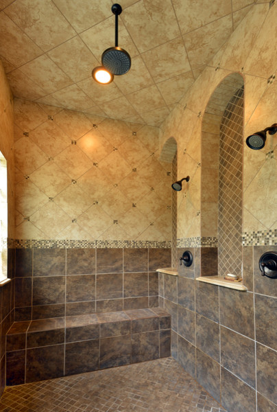 Inspiration for a large mediterranean master bathroom in Austin with a drop-in sink, raised-panel cabinets, dark wood cabinets, granite benchtops, a drop-in tub, a corner shower, a two-piece toilet, beige tile, stone tile, brown walls and travertine floors.