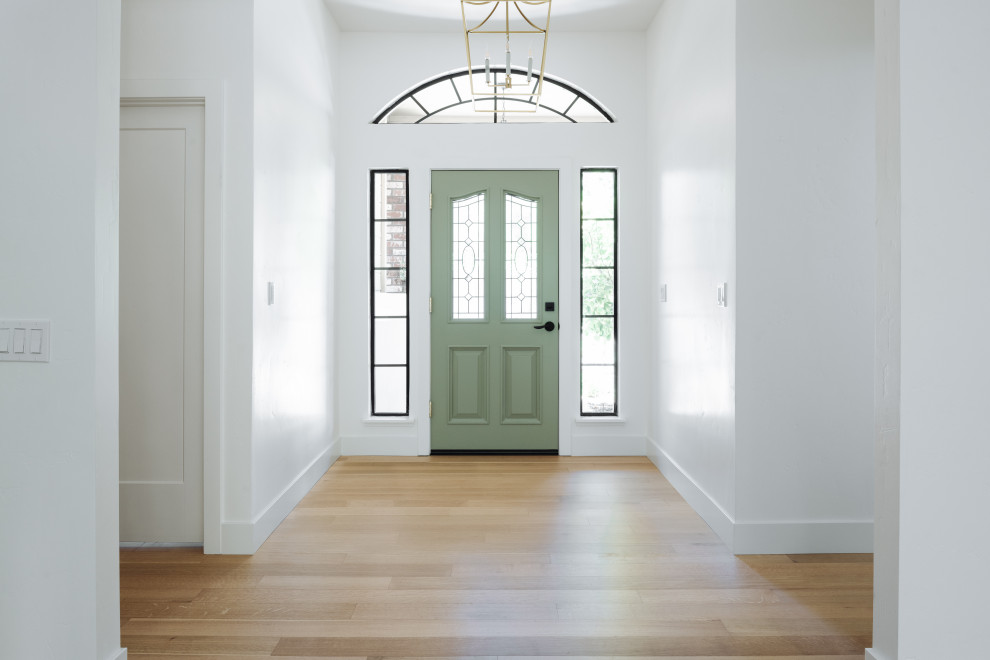 Imagen de distribuidor tradicional renovado grande con paredes blancas, suelo de madera clara, puerta simple y puerta verde
