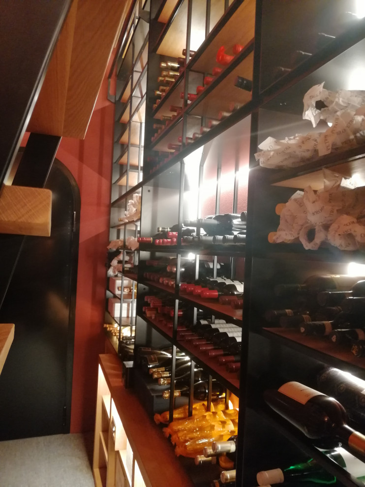 Inspiration for a mid-sized arts and crafts wine cellar in Milan with marble floors, display racks and grey floor.