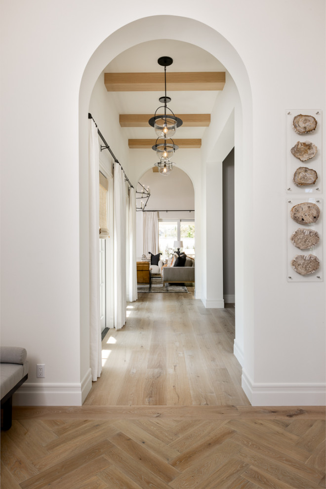Aménagement d'un couloir classique de taille moyenne avec un mur blanc, parquet clair et un sol beige.