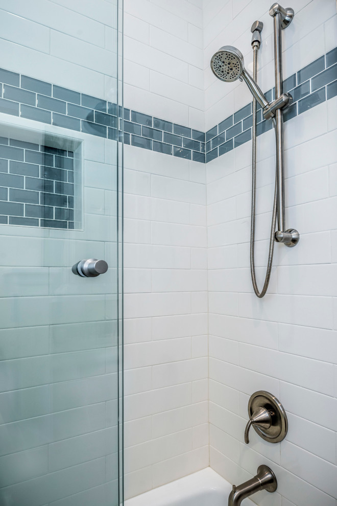 This is an example of a mid-sized country 3/4 bathroom in Chicago with an undermount sink, engineered quartz benchtops, a shower/bathtub combo, a two-piece toilet, blue tile, subway tile and porcelain floors.