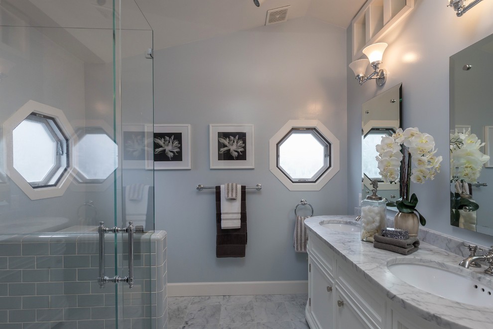 Small traditional 3/4 bathroom in San Francisco with recessed-panel cabinets, white cabinets, a corner shower, blue tile, ceramic tile, blue walls, marble floors, an undermount sink, marble benchtops, a hinged shower door and multi-coloured benchtops.