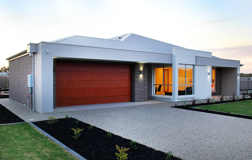 This is an example of a large contemporary one-storey brick house exterior in Adelaide with a metal roof.