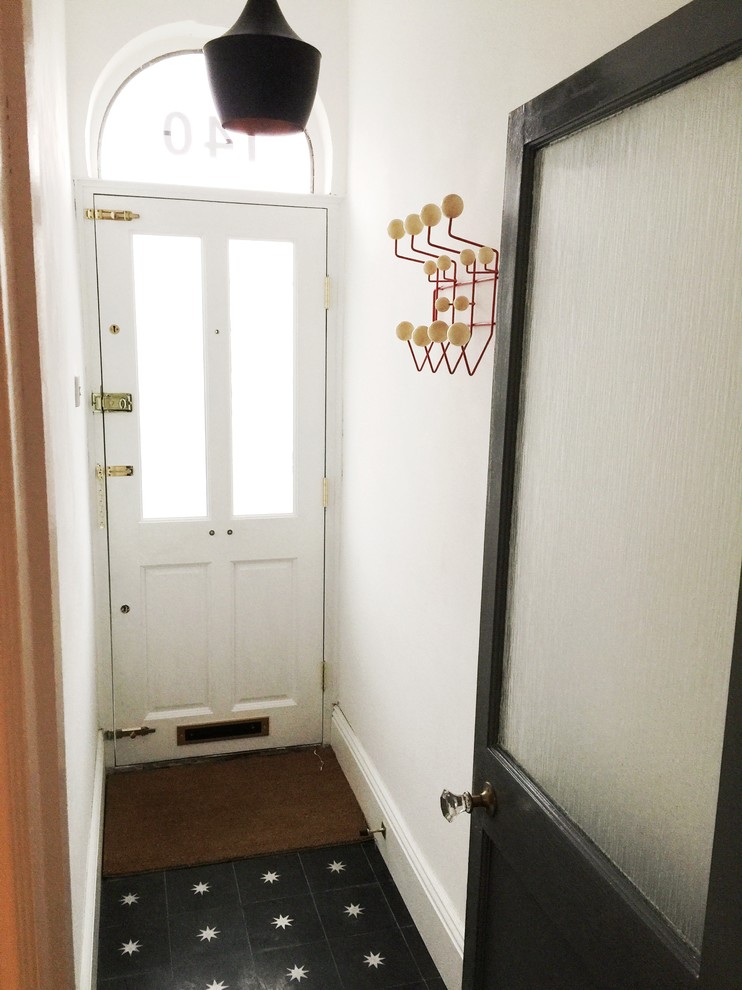 Photo of a small hallway in London with white walls and concrete floors.