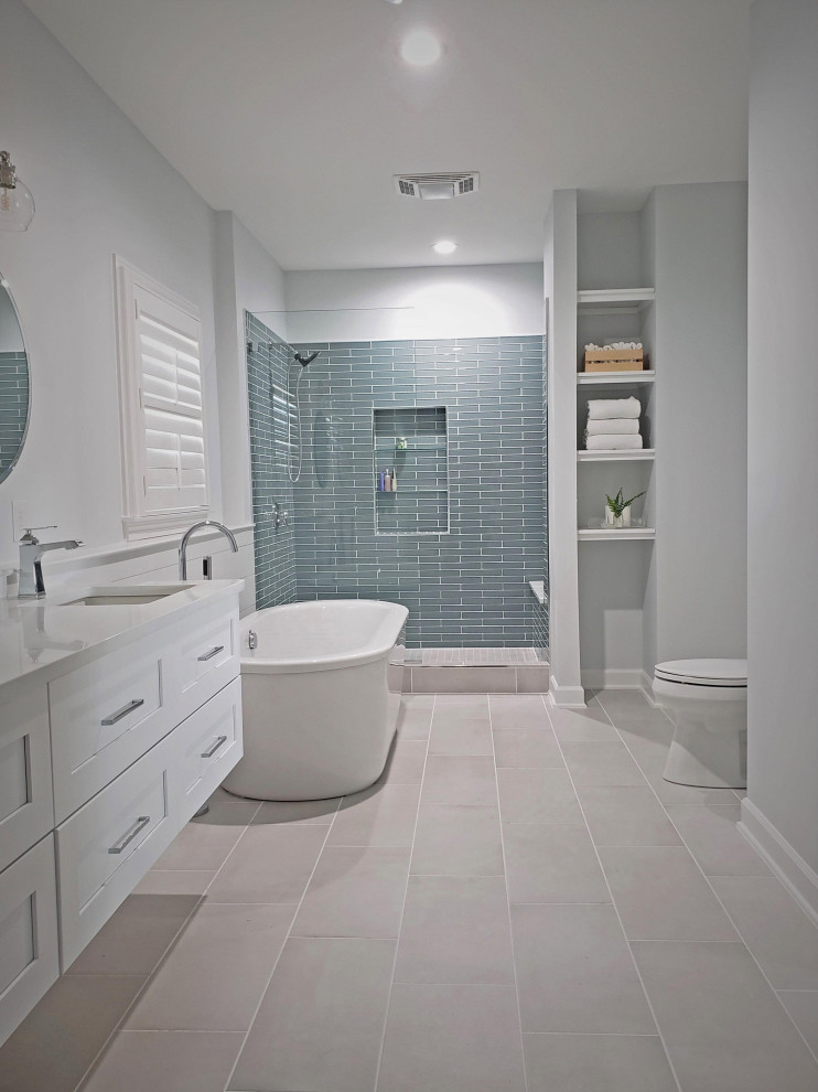 Design ideas for a large contemporary master bathroom in Nashville with shaker cabinets, white cabinets, a freestanding tub, an alcove shower, green tile, glass tile, white walls, porcelain floors, an undermount sink, engineered quartz benchtops, grey floor, an open shower, white benchtops, a niche, a double vanity, a freestanding vanity and planked wall panelling.