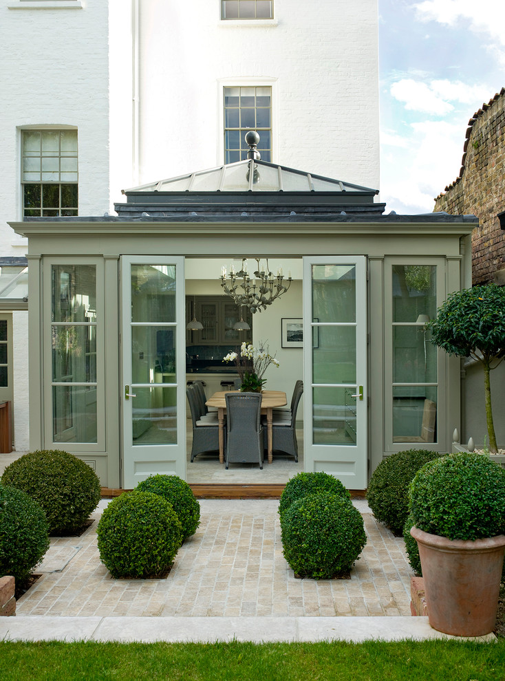 This is an example of a mid-sized traditional sunroom in London with a glass ceiling.