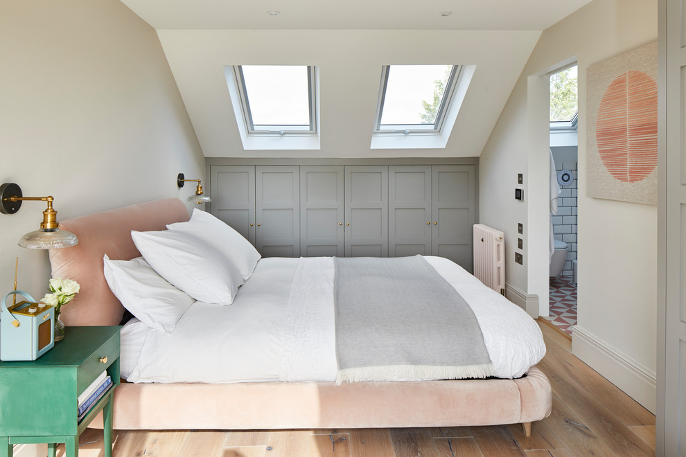 Transitional guest bedroom in London with white walls, medium hardwood floors and brown floor.