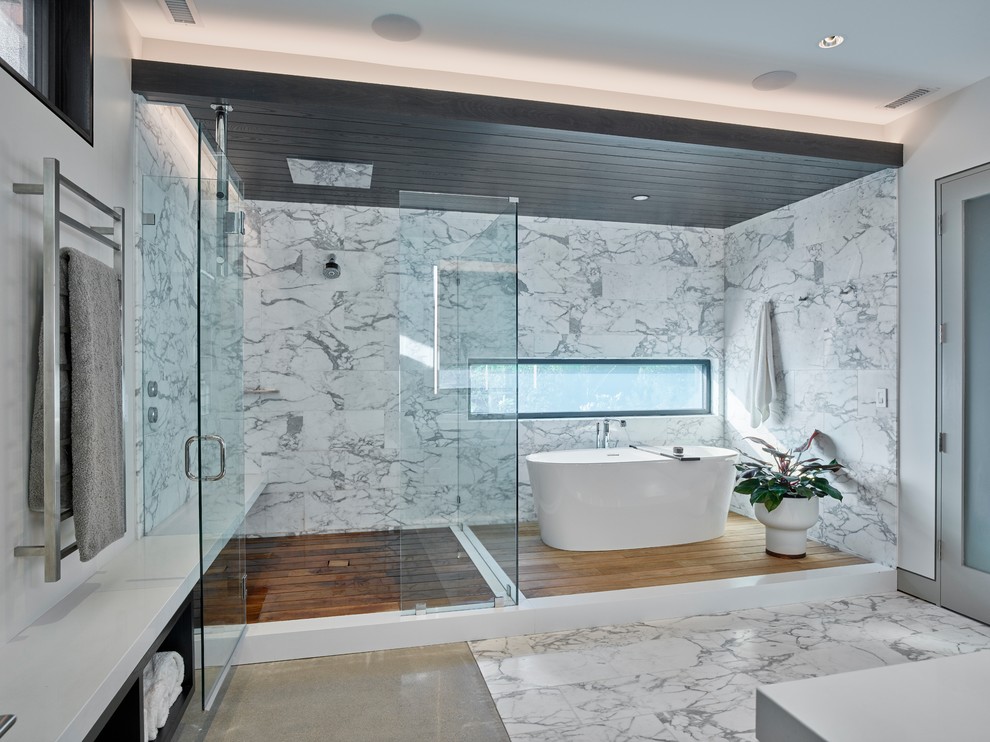 Inspiration for a large modern master bathroom in Other with a freestanding tub, a corner shower, white walls, a hinged shower door, flat-panel cabinets, black cabinets, an integrated sink, solid surface benchtops and white benchtops.