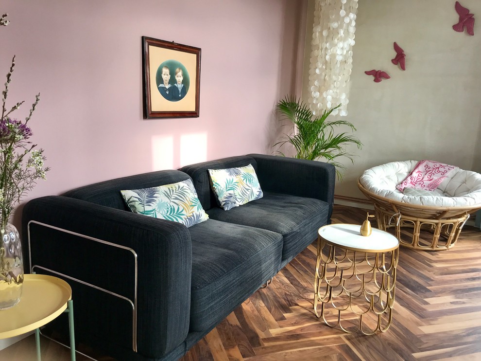 Offenes, Kleines Eklektisches Wohnzimmer ohne Kamin mit bunten Wänden, braunem Holzboden und braunem Boden in Berlin