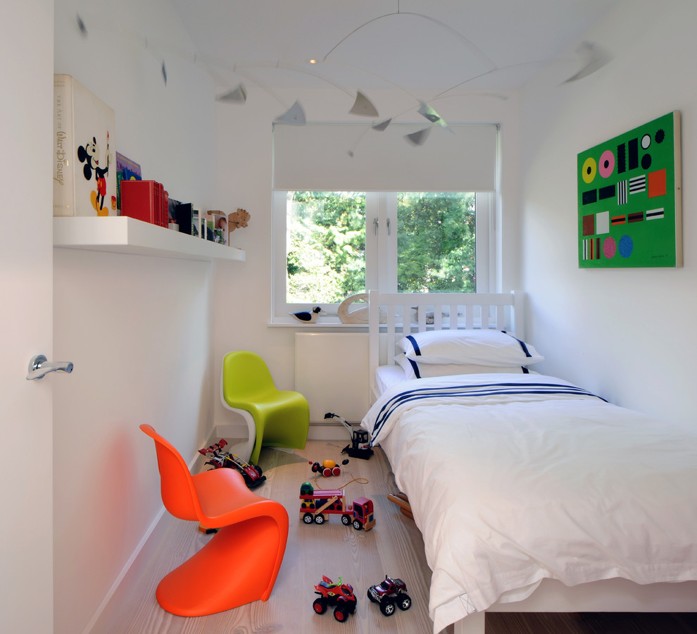 Design ideas for a small scandinavian gender-neutral kids' room in London with white walls and light hardwood floors.