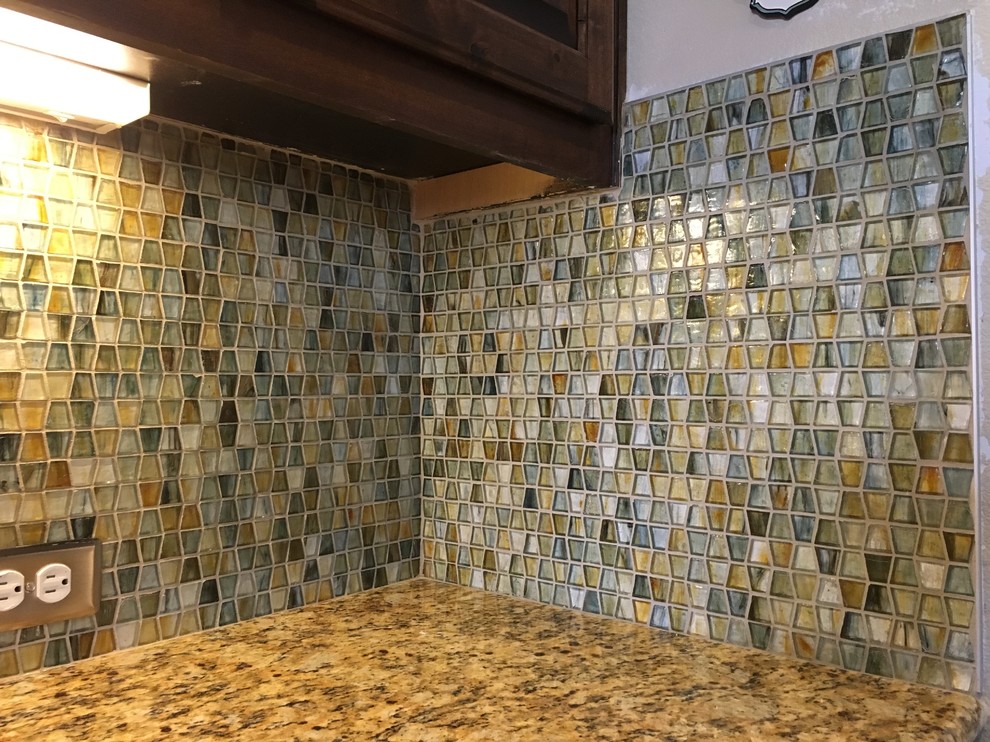 Example of a mid-sized transitional l-shaped eat-in kitchen design in Austin with an undermount sink, recessed-panel cabinets, dark wood cabinets, granite countertops, multicolored backsplash, glass sheet backsplash, stainless steel appliances and an island