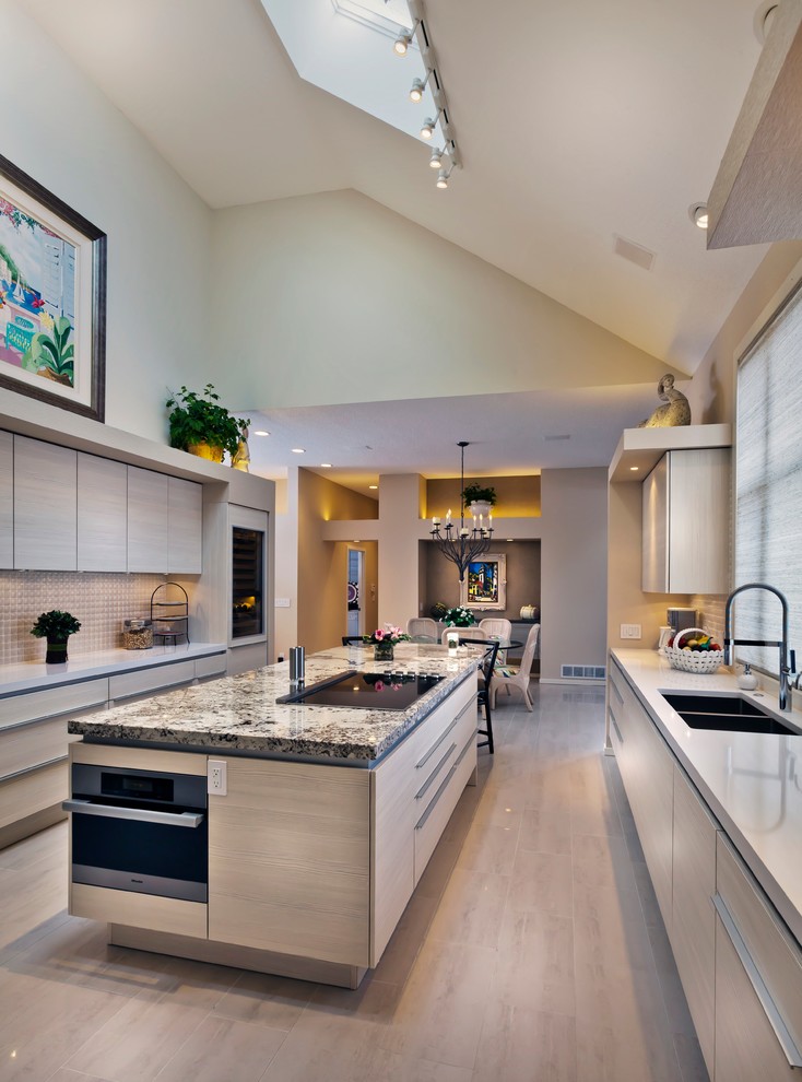 Design ideas for an expansive contemporary galley eat-in kitchen in Minneapolis with a double-bowl sink, flat-panel cabinets, light wood cabinets, white splashback, granite benchtops, porcelain splashback, panelled appliances, porcelain floors and with island.