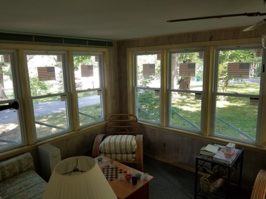 Vinyl windows replacing storm windows in a cottage porch