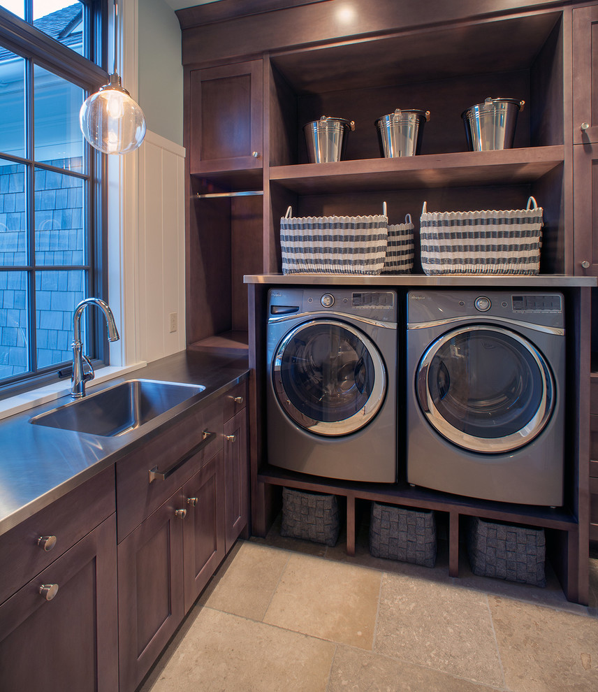Large transitional l-shaped laundry room in Grand Rapids with shaker cabinets, dark wood cabinets, ceramic floors, a side-by-side washer and dryer, beige floor, green walls, stainless steel benchtops and grey benchtop.