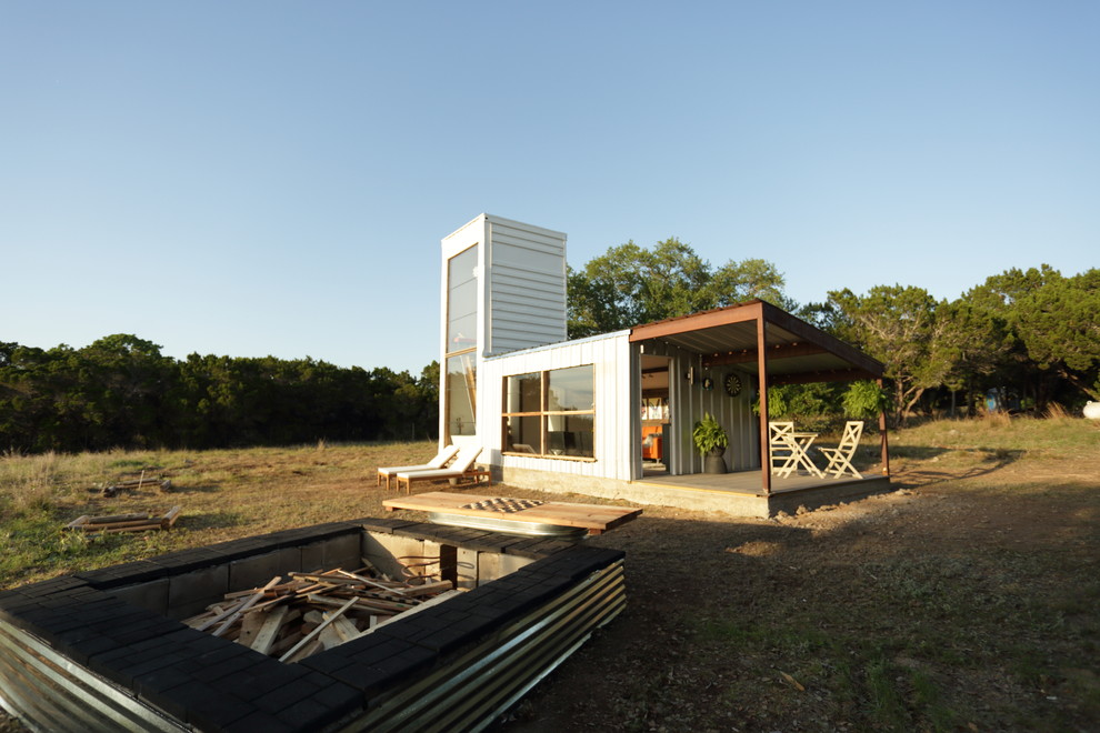 Small contemporary white two-story metal exterior home idea with a shed roof and a metal roof