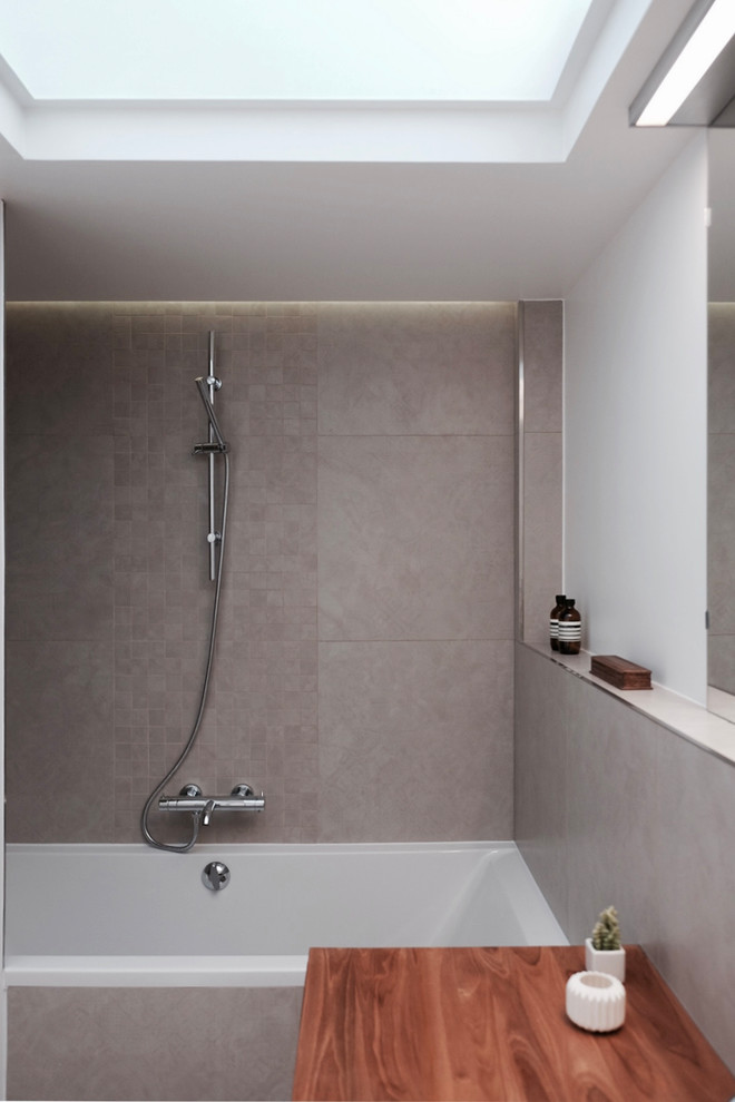 Design ideas for a small contemporary 3/4 bathroom in Paris with an undermount tub, pink tile, pink walls and grey floor.