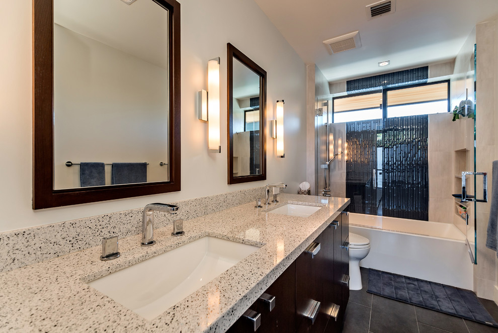 Design ideas for a large modern bathroom in San Diego with flat-panel cabinets, dark wood cabinets, engineered quartz benchtops, blue tile, glass tile, an undermount sink, an alcove tub, a shower/bathtub combo, a one-piece toilet, grey walls and ceramic floors.