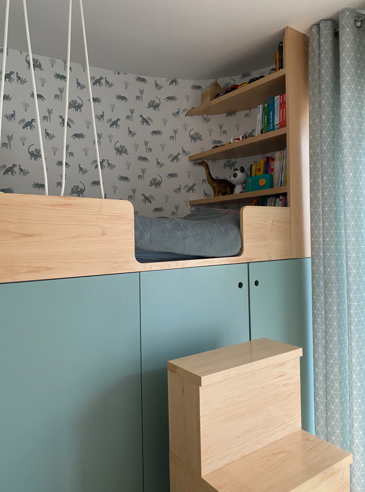 This is an example of a small contemporary children’s room for boys in Paris with medium hardwood flooring and wallpapered walls.