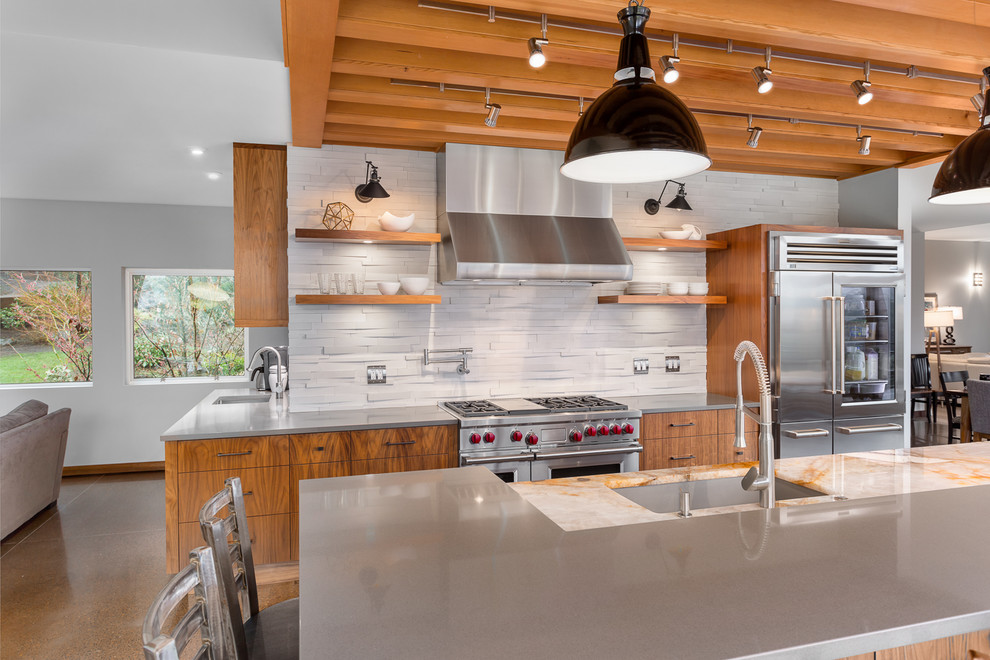 Inspiration for a large contemporary galley eat-in kitchen in Portland with an undermount sink, flat-panel cabinets, medium wood cabinets, granite benchtops, beige splashback, stone tile splashback, stainless steel appliances, concrete floors and with island.