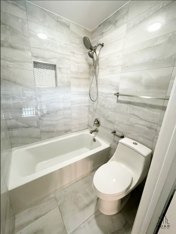 Modern inredning av ett litet vit vitt en-suite badrum, med luckor med profilerade fronter, grå skåp, ett badkar i en alkov, vita väggar, ljust trägolv, marmorbänkskiva och brunt golv