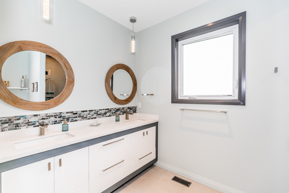 Inspiration for a mid-sized modern bathroom in Other with shaker cabinets, white cabinets, an alcove shower, a one-piece toilet, multi-coloured tile, subway tile, white walls, an undermount sink, beige floor, a hinged shower door and white benchtops.