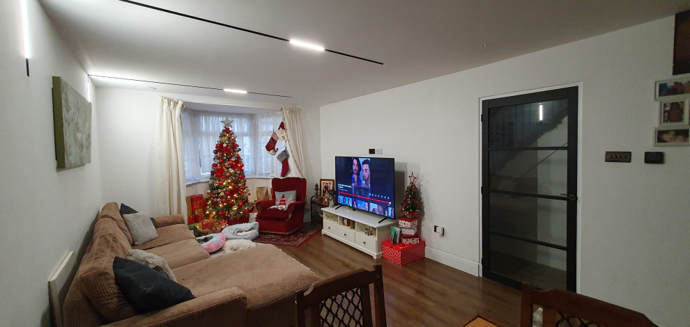 Example of a large trendy open concept laminate floor and multicolored floor family room design in London with a music area, white walls, no fireplace and a tv stand