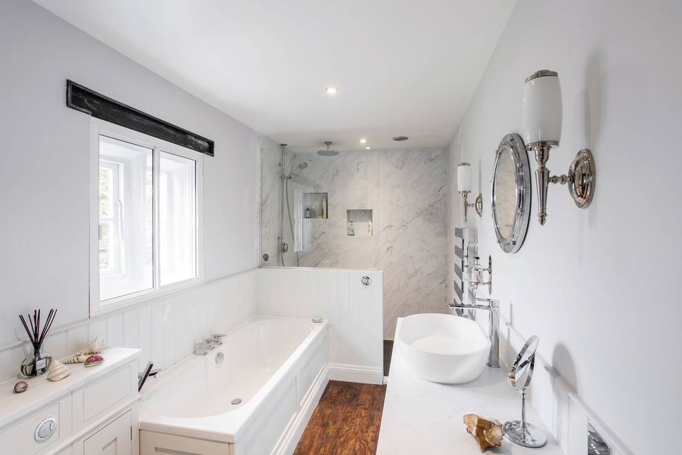 This is an example of a small contemporary kids bathroom in Kent with shaker cabinets, a drop-in tub, an open shower, white walls, vinyl floors, solid surface benchtops, white cabinets, a one-piece toilet, white tile, marble, a vessel sink, brown floor, an open shower and white benchtops.