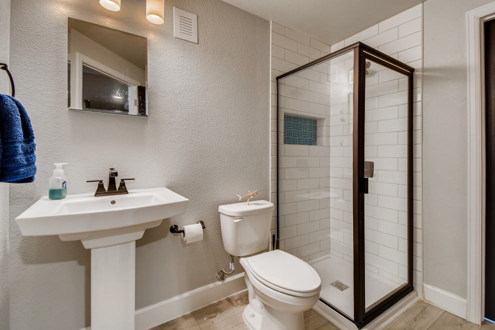Inspiration for a mid-sized modern 3/4 white tile and ceramic tile vinyl floor, gray floor, single-sink and wallpaper corner shower remodel in Denver with white walls, a pedestal sink, a hinged shower door and a niche