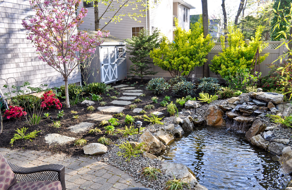 Design ideas for a traditional garden in New York with with waterfall.