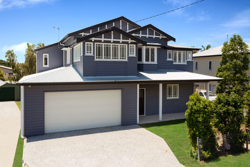 Photo of a large traditional two-storey grey exterior in Brisbane with vinyl siding and a gable roof.