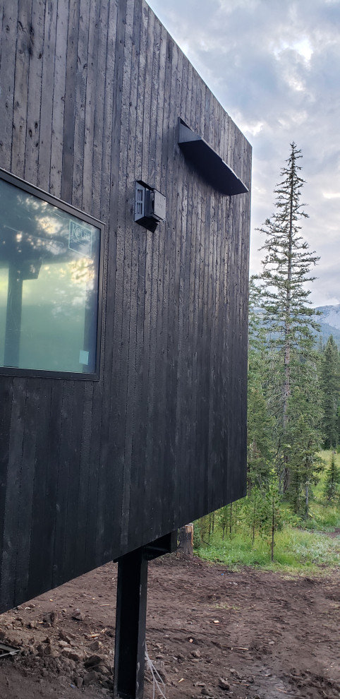This is an example of an industrial black house exterior in Other with wood siding.