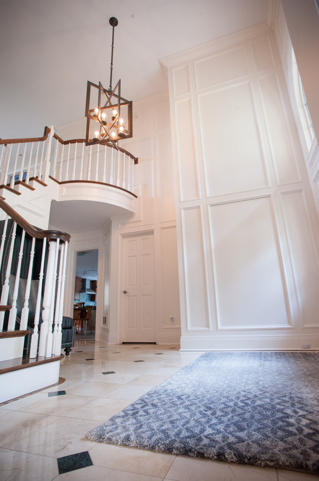 Photo of a large transitional foyer in Chicago with white walls, marble floors, a single front door, a black front door and beige floor.