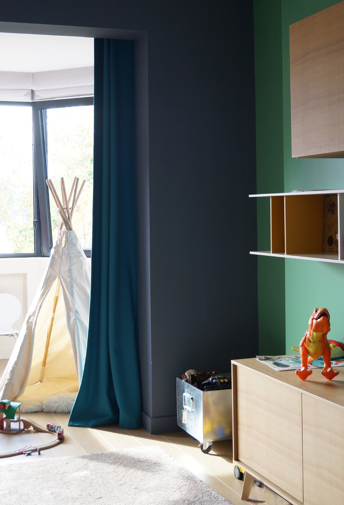 Photo of a mid-sized contemporary kids' playroom for kids 4-10 years old and boys in Paris with multi-coloured walls and light hardwood floors.