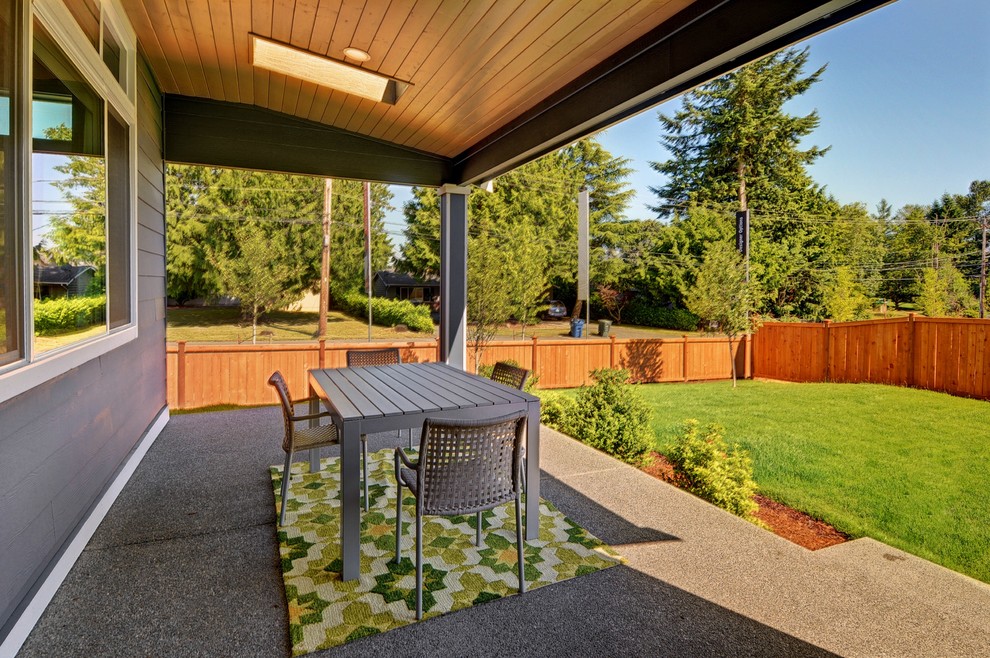 Inspiration for a transitional backyard concrete patio remodel in Seattle with a roof extension