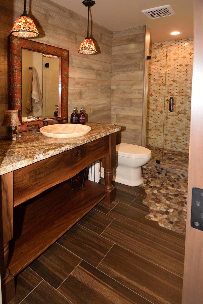 Inspiration for a large country 3/4 bathroom in Other with furniture-like cabinets, dark wood cabinets, an alcove shower, a one-piece toilet, multi-coloured tile, ceramic tile, beige walls, ceramic floors, a vessel sink, granite benchtops, a hinged shower door and brown floor.