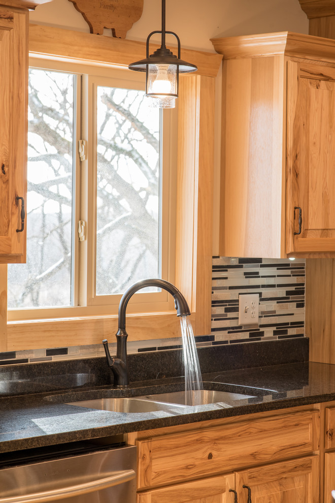 Mid-sized mountain style l-shaped light wood floor open concept kitchen photo in Minneapolis with a double-bowl sink, raised-panel cabinets, light wood cabinets, granite countertops, multicolored backsplash, matchstick tile backsplash, stainless steel appliances and an island