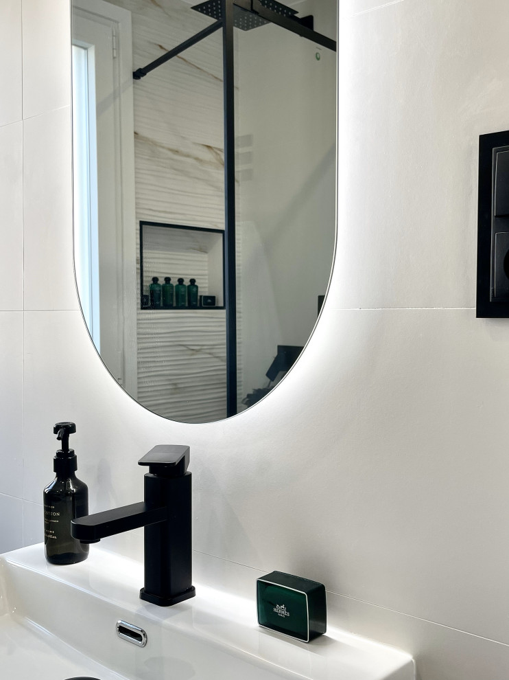 Пример оригинального дизайна: главная ванная комната среднего размера, в белых тонах с отделкой деревом в стиле модернизм с фасадами островного типа, светлыми деревянными фасадами, унитазом-моноблоком, белой плиткой, белыми стенами, полом из керамической плитки, настольной раковиной, столешницей терраццо, бежевым полом, душем с раздвижными дверями, белой столешницей, нишей, тумбой под одну раковину, встроенной тумбой, многоуровневым потолком и кирпичными стенами