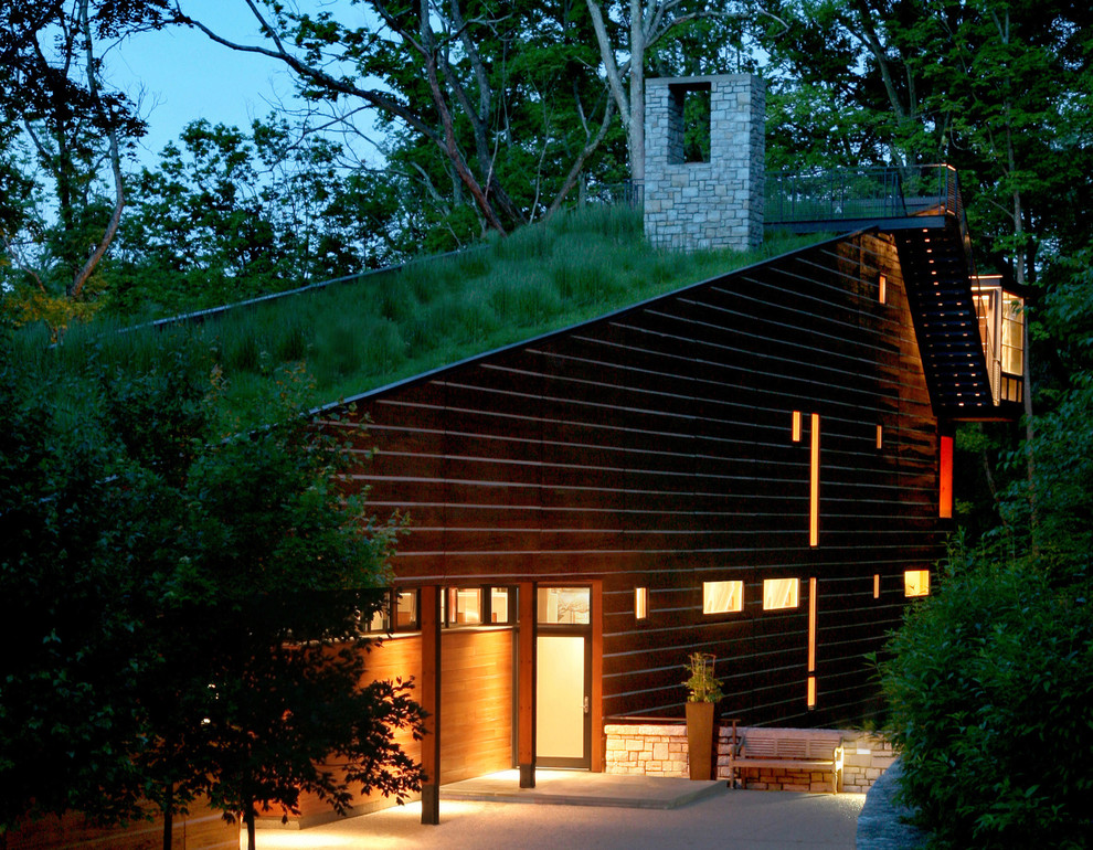 This is an example of a large contemporary three-storey brown house exterior in Cincinnati with wood siding, a green roof and a shed roof.