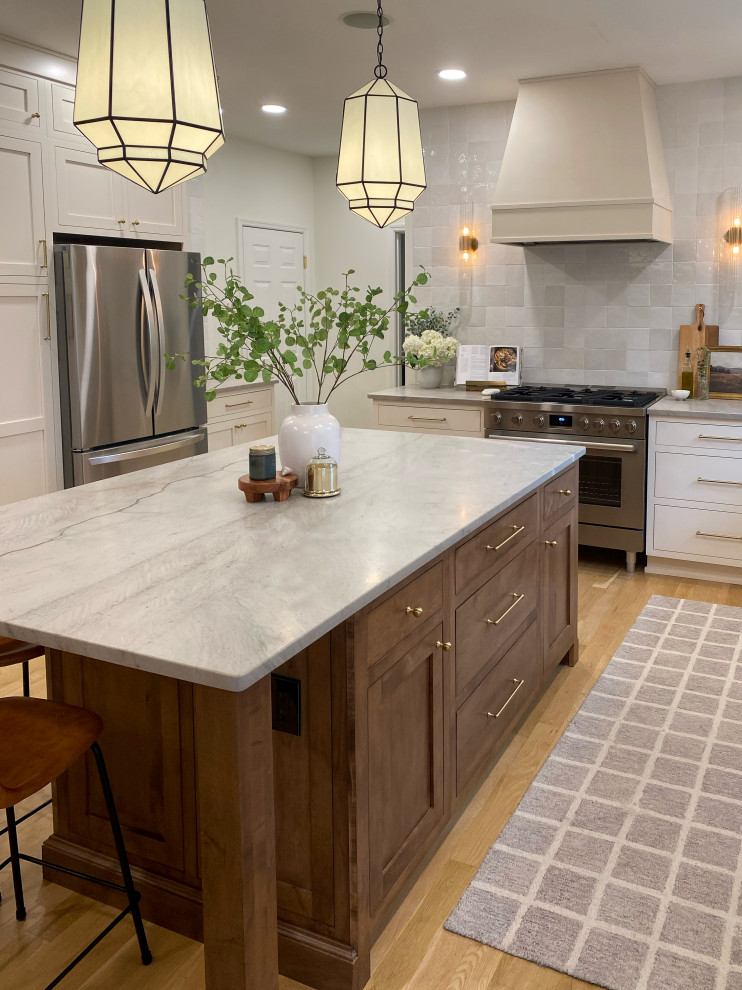 Mid-sized transitional u-shaped light wood floor and brown floor eat-in kitchen photo with shaker cabinets, dark wood cabinets, soapstone countertops, gray backsplash, subway tile backsplash, stainless steel appliances, an island and gray countertops