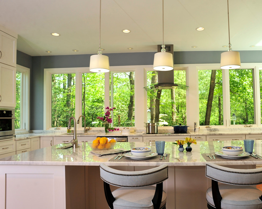 Example of a large transitional u-shaped medium tone wood floor kitchen design in DC Metro with an undermount sink, shaker cabinets, white cabinets, granite countertops, stainless steel appliances and an island