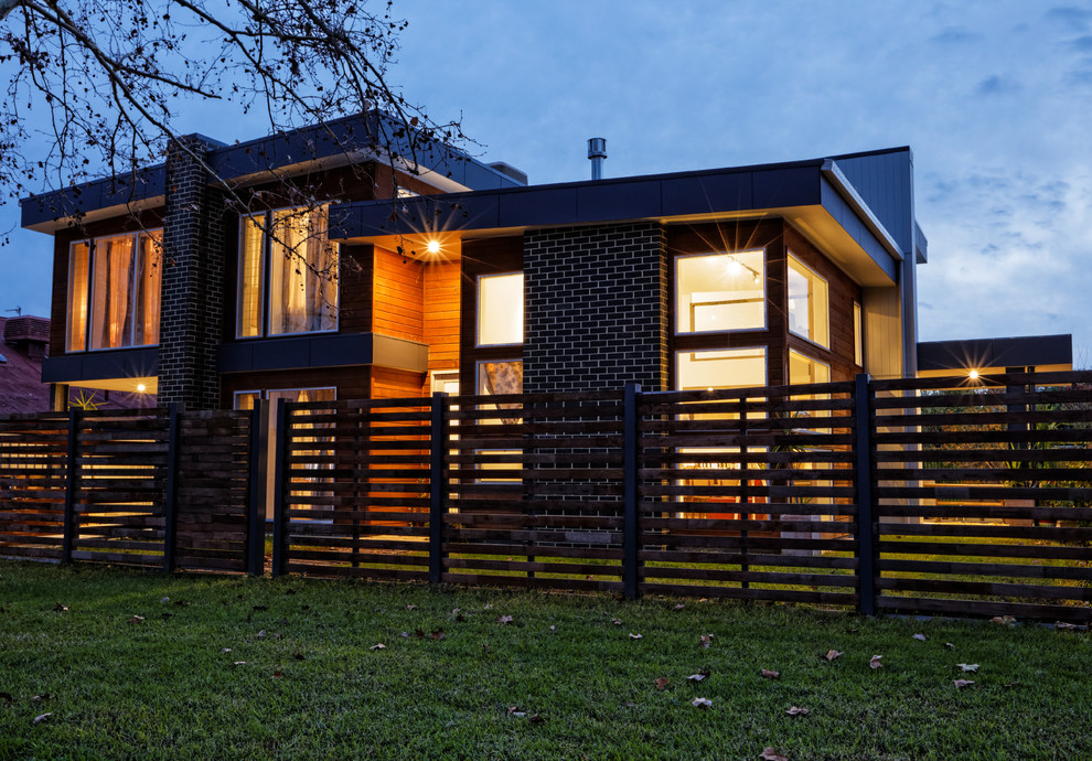 Design ideas for a mid-sized modern two-storey brown exterior in Sydney with wood siding and a flat roof.