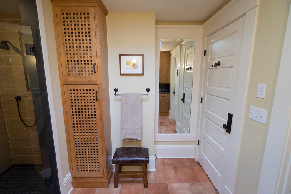 This is an example of a mid-sized arts and crafts 3/4 bathroom in Seattle with shaker cabinets, medium wood cabinets, a corner shower, a two-piece toilet, black tile, porcelain tile, yellow walls, porcelain floors, a pedestal sink and tile benchtops.