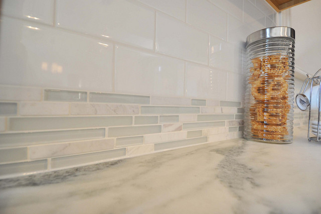 Open concept kitchen - mid-sized transitional galley concrete floor open concept kitchen idea in St Louis with a farmhouse sink, shaker cabinets, medium tone wood cabinets, granite countertops, white backsplash, ceramic backsplash, stainless steel appliances and an island
