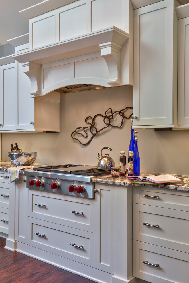 This is an example of a mid-sized traditional l-shaped eat-in kitchen in Charlotte with an undermount sink, shaker cabinets, white cabinets, granite benchtops, stainless steel appliances, dark hardwood floors and with island.